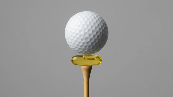 Studio photography of a golf ball perfectly balanced on a golden Phosphatidylserine capsule sitting on a wooden tee, visualizing the stabilization of nerves and prevention of the 'yips' in athletic performance.